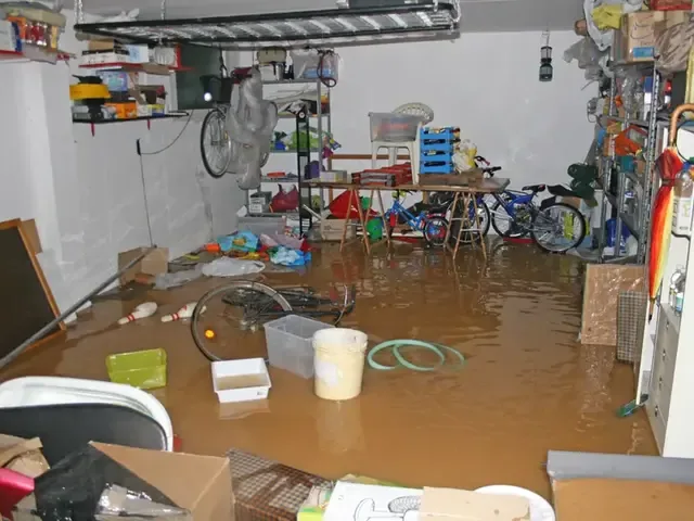 Standing water spread across the floor of a crowded basement storage room