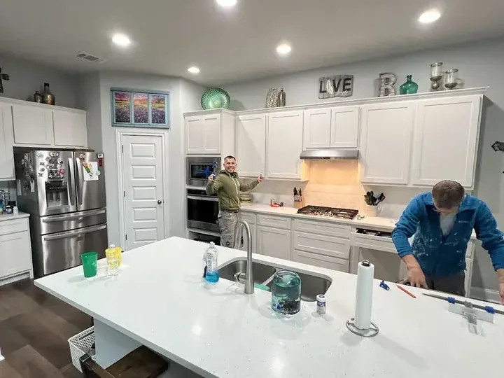 A restoration crew rebuilding a kitchen after a supply hose leak