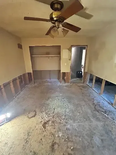 Crew member removing wet carpet and pad from a flooded room during cleanup