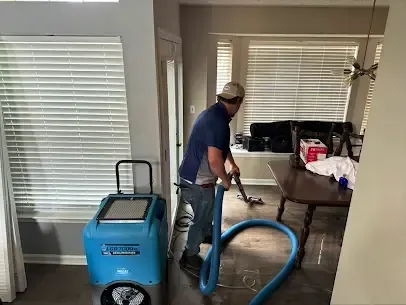 Air movers and a dehumidifier drying an opened wall cavity after a supply pipe leak