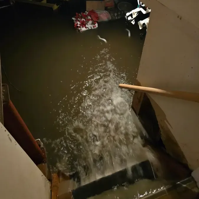 Storm runoff pouring down the stairs into a basement